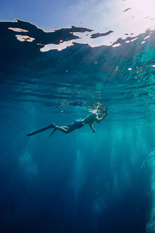 Taucher unter Wasser mit Tauchflossen und Taucherbrille